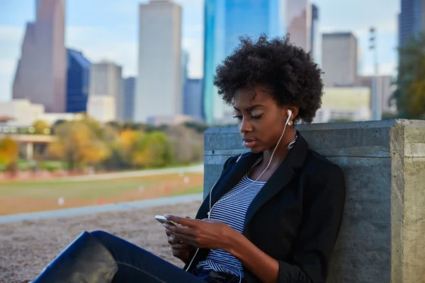 Vrouw met smartphone zit in het park — Stockfoto