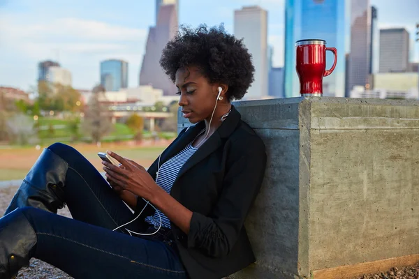 Vrouw met smartphone zit in het park — Stockfoto