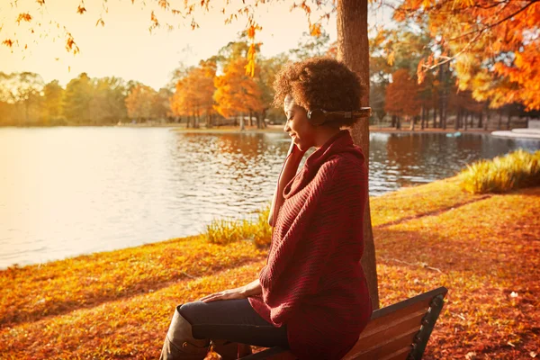 Γυναίκα ακούγοντας μουσική στο πάρκο φθινόπωρο — Φωτογραφία Αρχείου