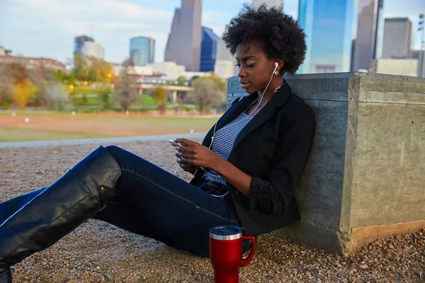 Vrouw met smartphone zit in het park — Stockfoto