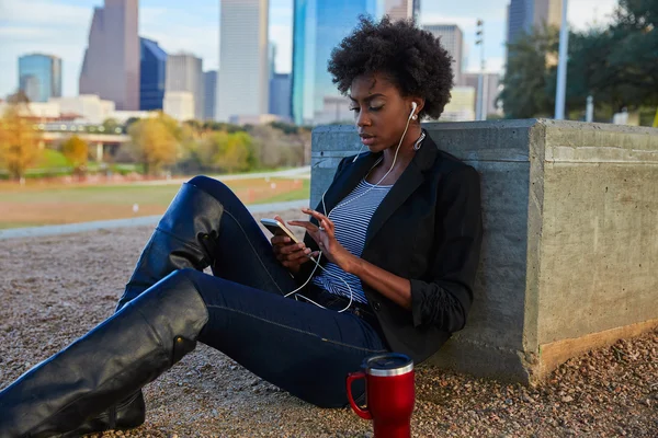 Vrouw met smartphone zit in het park — Stockfoto