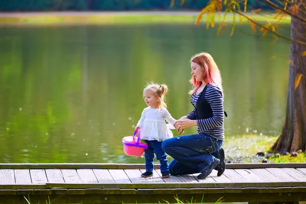 Kluk holka a matka hraje v parku lake — Stock fotografie