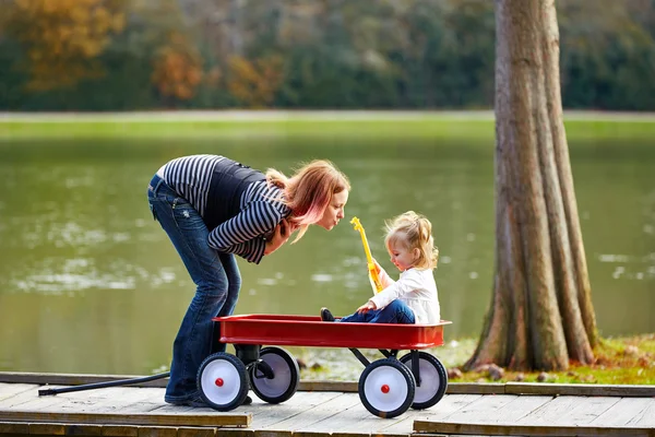 Ragazza e madre che giocano nel lago con il carretto — Foto Stock