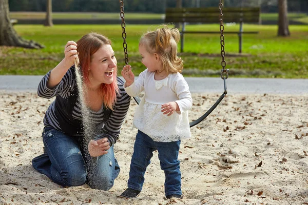 Madre e figlia giocano con la sabbia nel parco — Foto Stock