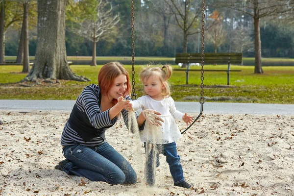 Anne ve kızı parkta kum ile oynamak