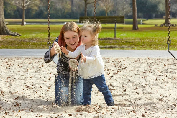 Mor och dotter leker med sand i park — Stockfoto