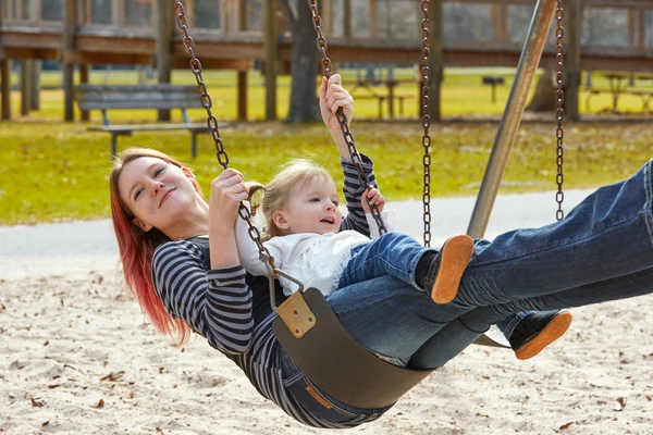 Mère et fille dans une balançoire au parc — Photo