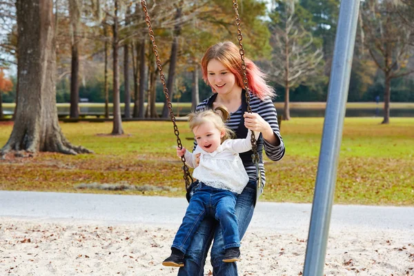 Мать и дочь на качелях в парке — стоковое фото