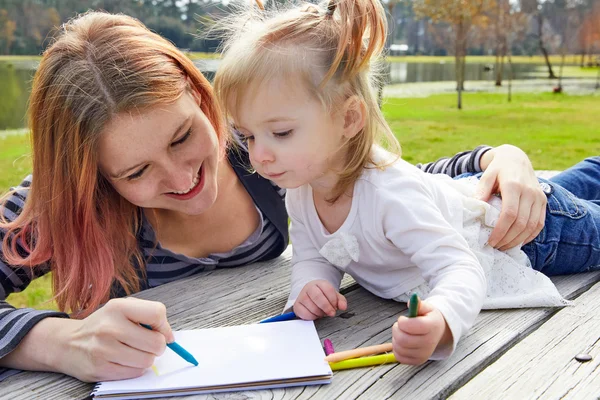 Mère et fille dessinent des couleurs dans un parc — Photo