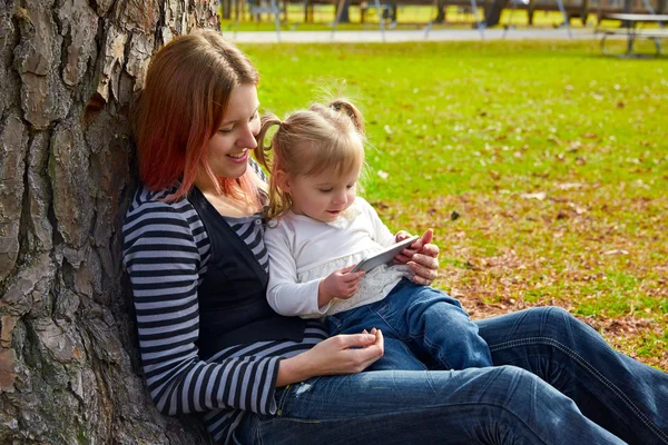 Mãe e filha brincando com smartphone — Fotografia de Stock