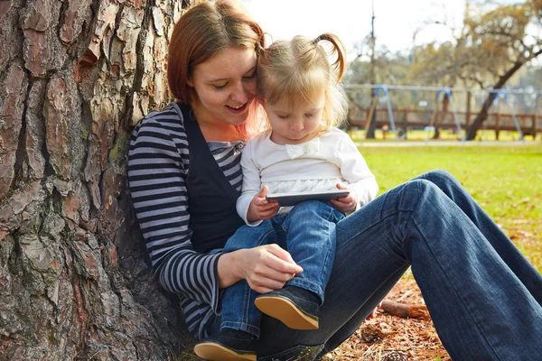 Mor och dotter leker med smartphone — Stockfoto