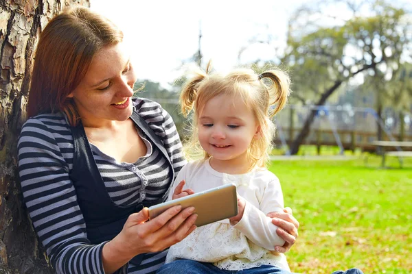 Moeder en dochter spelen met smartphone — Stockfoto