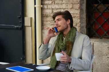Açık bir kafede smartphone ile genç adam