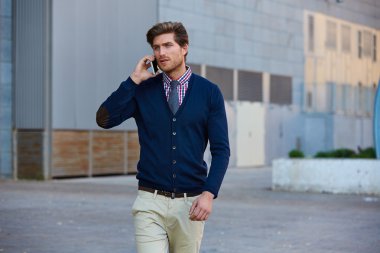 Genç işadamı Smartphone yürüyüş konuşuyor 