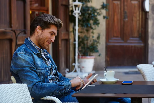 Jovem com tablet pc toque em um café — Fotografia de Stock