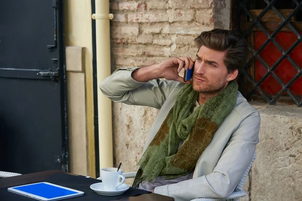 Hombre joven con teléfono inteligente en un café al aire libre —  Fotos de Stock