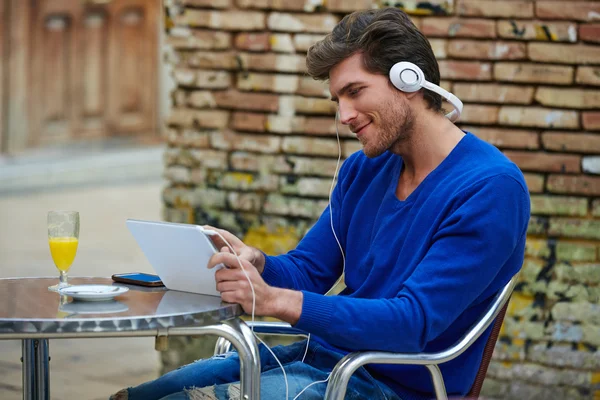 Jonge man met tablet pc touch luisteren muziek — Stockfoto