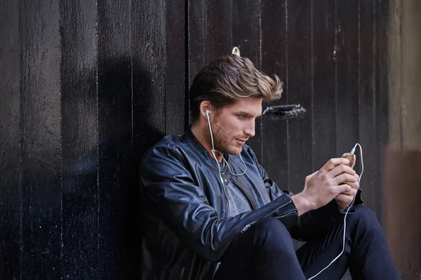Young man listening music smartphone earphones — Stock Photo, Image