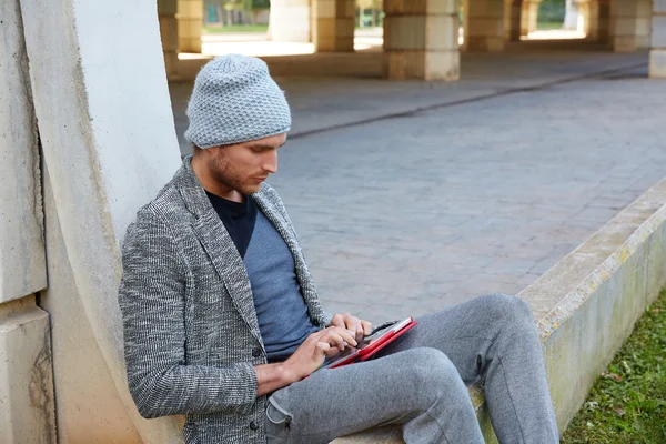 Jovem moderno com tablet pc sob uma ponte — Fotografia de Stock