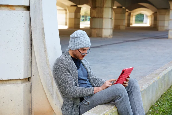 Jovem moderno com tablet pc sob uma ponte — Fotografia de Stock