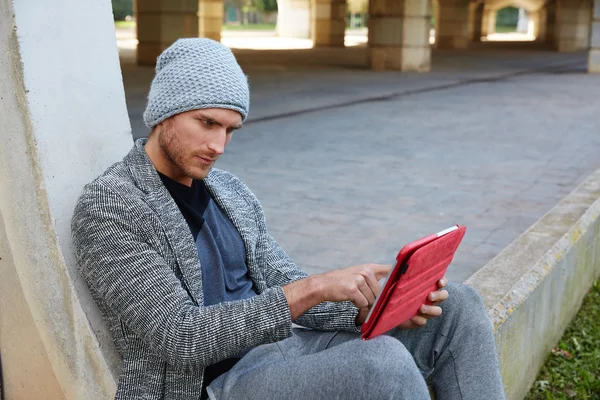 Joven moderno con tableta pc bajo un puente —  Fotos de Stock