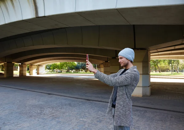Modern young man with tablet pc under a bridge — Stock Photo, Image