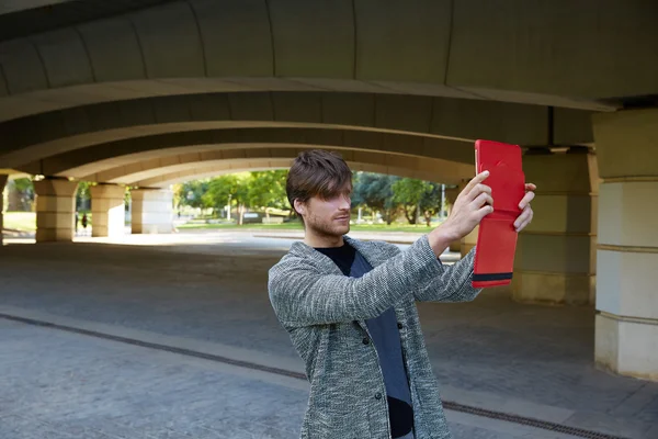 Jovem moderno com tablet sob uma ponte — Fotografia de Stock