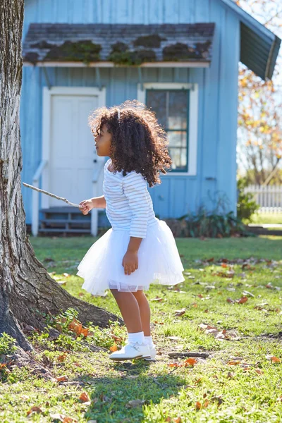 Kind Mädchen mit Ast Stock spielen draußen — Stockfoto