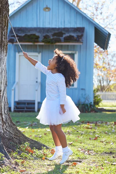 Menina criança com vara ramo jogando ao ar livre — Fotografia de Stock