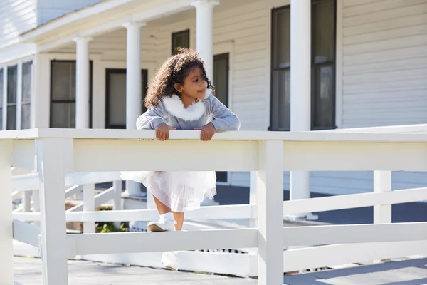 Kid toddler girl playing climbing a fence outdoor — Stock Photo, Image