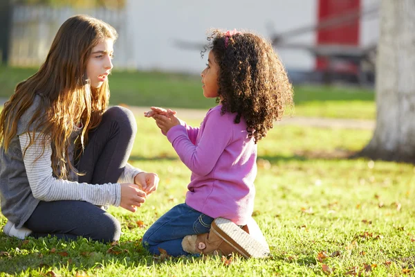 Kid meisjes spelen in park gras gemengde etniciteit — Stockfoto