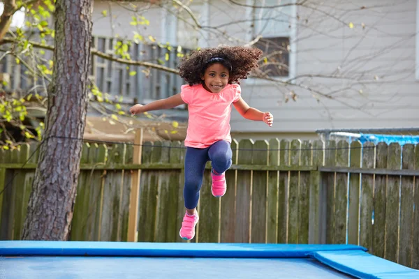 Ragazzina bambina che salta su un trampolino — Foto Stock