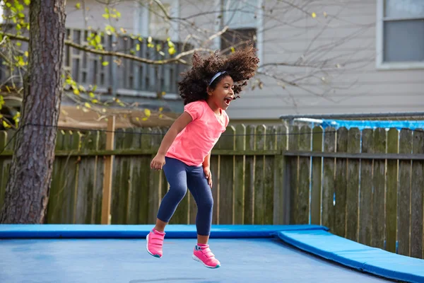 Kid toddler girl jumping on a trampoline — Stock Photo, Image