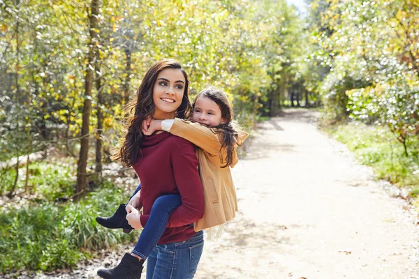 Madre e figlia si divertono a cavalcare in un parco — Foto Stock