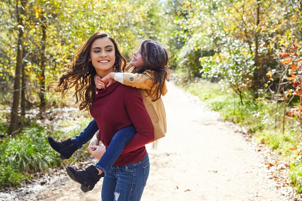 Mutter und Tochter amüsieren sich huckepack im Park — Stockfoto
