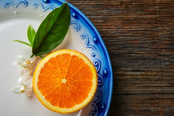 Cut open orange fruit with orange flower — Stock Photo, Image
