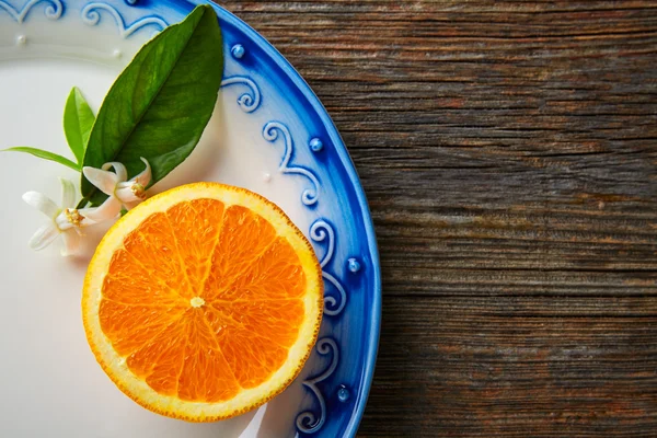 Cut open orange fruit with orange flower — Stock Photo, Image