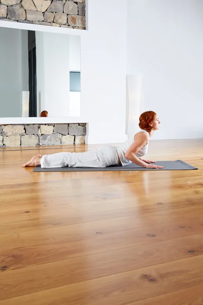 Ejercicio de yoga en piso de madera gimnasio y espejo —  Fotos de Stock