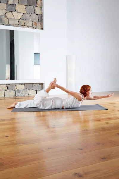 Ejercicio de yoga en piso de madera gimnasio y espejo — Foto de Stock