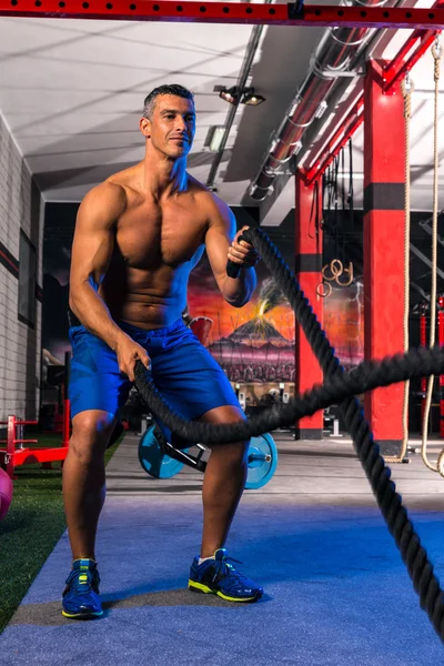 Hombre de las cuerdas de batalla en el ejercicio de entrenamiento de gimnasio — Foto de Stock