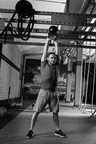 Kettleblell swinging man weightlifting workout gym — Stock Photo, Image