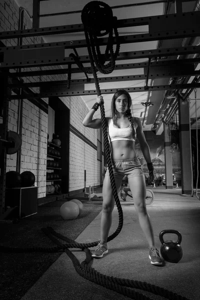 Hermosa chica ajustada en el gimnasio con cuerda negra —  Fotos de Stock