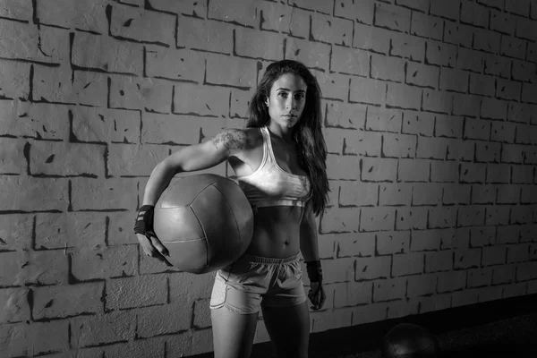 Morena ginásio menina segurando bola ponderada — Fotografia de Stock