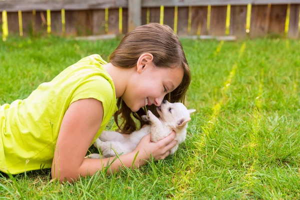 Kid flicka och valp hund glad liggande i gräsmatta — Stockfoto