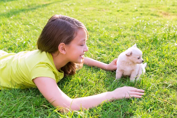 Menina criança e cachorro cão feliz deitado no gramado — Fotografia de Stock