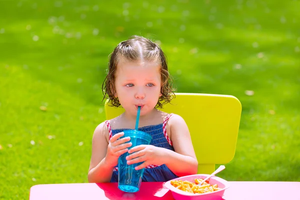 Criança menina bebendo comer macarrão no jardim — Fotografia de Stock