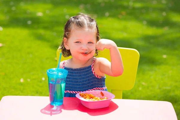 Criança menina comendo macarrão massa de tomate — Fotografia de Stock