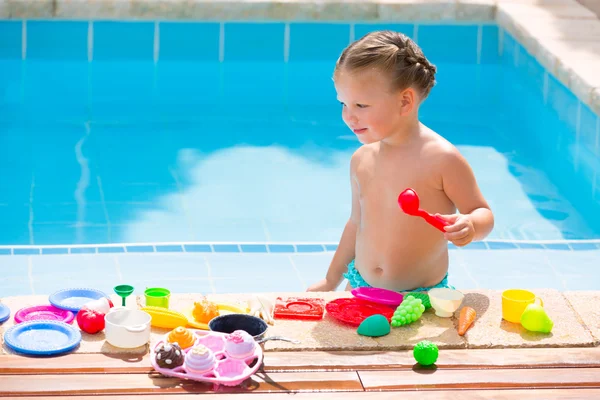 Menina criança brincando de brinquedos de comida na piscina — Fotografia de Stock