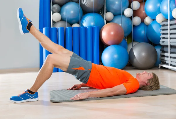 Hip lift with leg extension blond man gym exercise — Stock Photo, Image