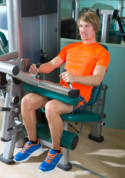 Gym zitten been curl machine oefening blond man — Stockfoto